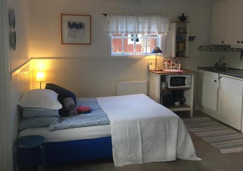 a bedroom with a bed and a small kitchen at Lillstugan Elofstorp in Kristinehamn
