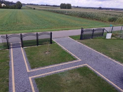 a walkway with a cross in the middle of a field at Domek mamy in Tykocin