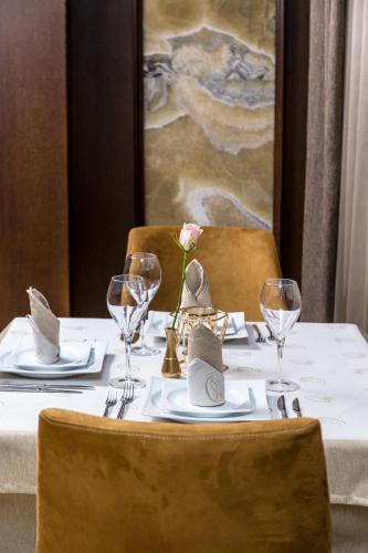 a table with a white table cloth and a flower on it at Onyx Beach Residence - Free Parking & Beach Access in Sveti Vlas