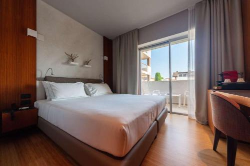 a bedroom with a large bed and a large window at Hotel Ocelle Thermae&Spa (Adults Only) in Sirmione