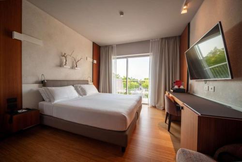 a hotel room with a bed and a large window at Hotel Ocelle Thermae&Spa (Adults Only) in Sirmione