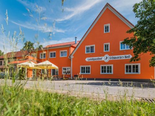 ein Gebäude mit einem orangefarbenen Gebäude in der Unterkunft Landgasthof Schwarzes Roß in Ansbach