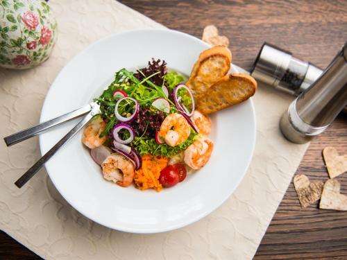a plate of food with shrimp and salad on a table at Landgasthof Schwarzes Roß in Ansbach