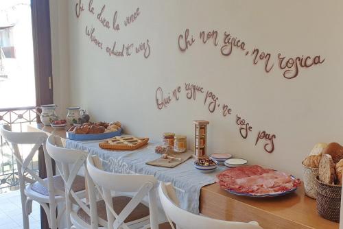 un tavolo con pane e cibo sopra con un cartello sul muro di Casa Parthenope a Ercolano