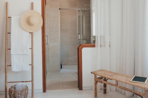 a bathroom with a shower with a bench and a table at Joy Beach House in São Pedro de Moel