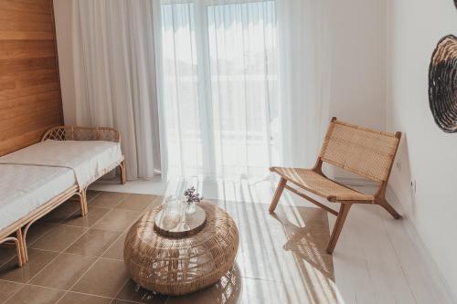 a room with a bed and a chair and a table at Joy Beach House in São Pedro de Moel