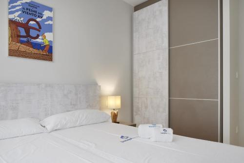 1 dormitorio con 1 cama blanca y 2 toallas en Pausoka - Basque Stay en San Sebastián