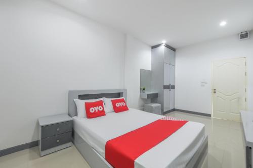 una camera da letto con un grande letto con cuscini rossi di OYO 1159 K&k Apartment a Samutprakarn