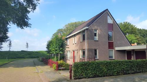 a brick house with a red door on a street at Holiday apartment with free parking Boven Jan Enkhuizen in Enkhuizen