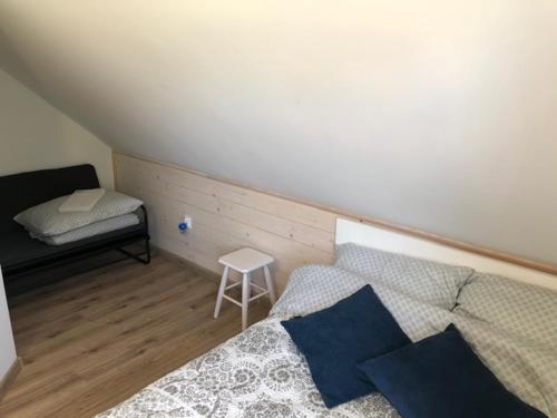 1 dormitorio con 1 cama y un banco en una habitación en Domki Apartamentowe Orłówka, en Jantar