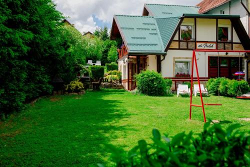 a house with a green lawn in front of it at Apartments Predah, Mijaila Radovica 13a in Zlatibor