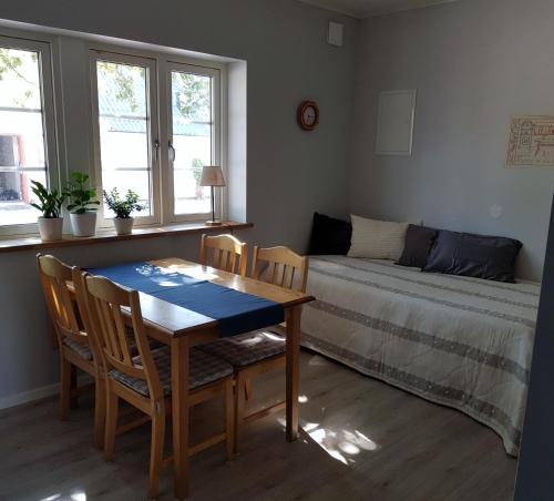 uma sala de jantar com uma mesa e cadeiras e uma cama em Komleryd em Långås