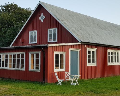 een rode schuur met twee stoelen ervoor bij Komleryd in Långås