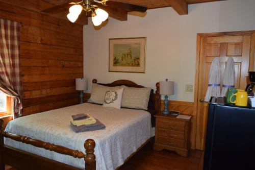 - une chambre avec un lit et un mur en bois dans l'établissement Creekside Paradise Bed and Breakfast, à Robbinsville