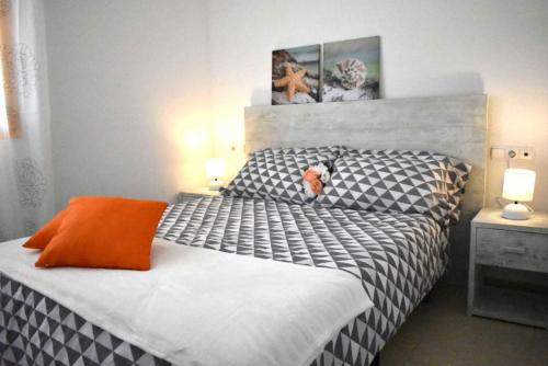 a bedroom with a black and white bed with an orange pillow at ROCASOL - Beach in Calpe