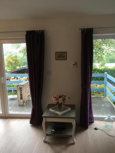 a living room with a table with a vase of flowers at Ferienwohnung Jacobshof in Oberstedem