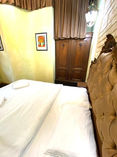 a bedroom with a bed with white sheets at Квартира подобово на Площі Ринок 39 in Lviv