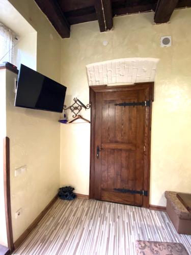 a room with a door and a tv on the wall at Квартира подобово на Площі Ринок 39 in Lviv