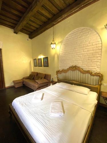 a bedroom with a large bed and a brick wall at Квартира подобово на Площі Ринок 39 in Lviv