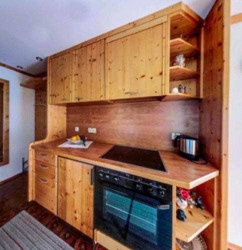 uma cozinha com armários de madeira e um forno com placa de fogão em Ferienwohnung Hallweger em Ruhpolding
