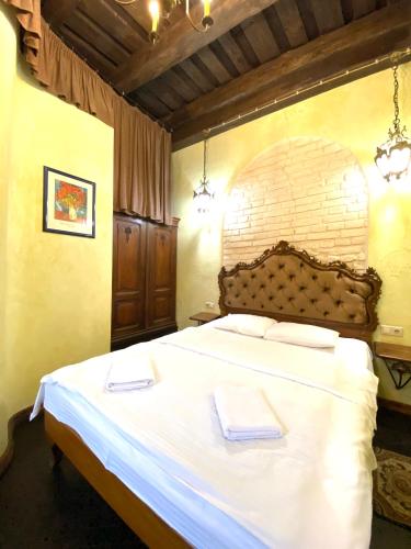 a bedroom with a large bed with two towels on it at Квартира подобово на Площі Ринок 39 in Lviv