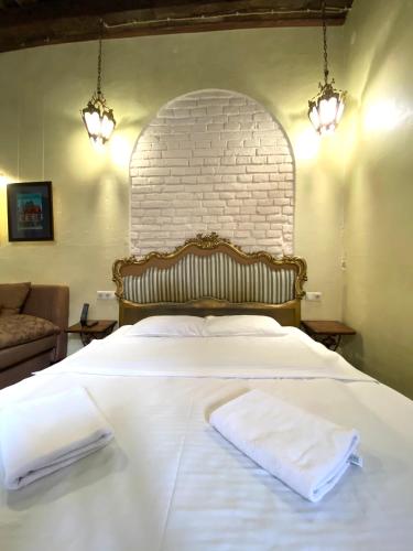 a bedroom with a white bed with two towels on it at Квартира подобово на Площі Ринок 39 in Lviv