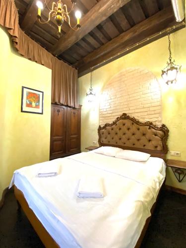 a bedroom with a large bed with two towels on it at Квартира подобово на Площі Ринок 39 in Lviv
