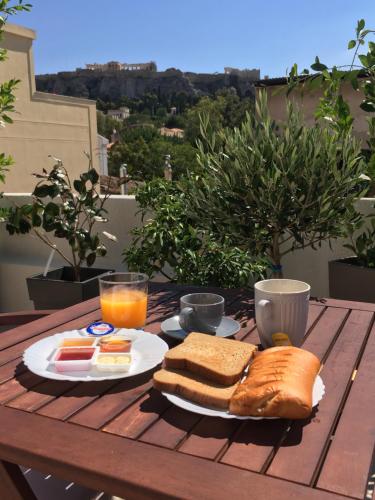 a table with a plate of sandwiches and orange juice at Theasis Athens in Athens