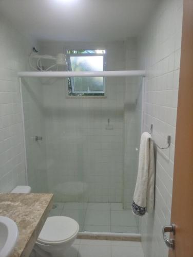 uma casa de banho com um chuveiro, um WC e um lavatório. em Apto. Vila dos Lírios - Reserva Imbassai em Imbassaí