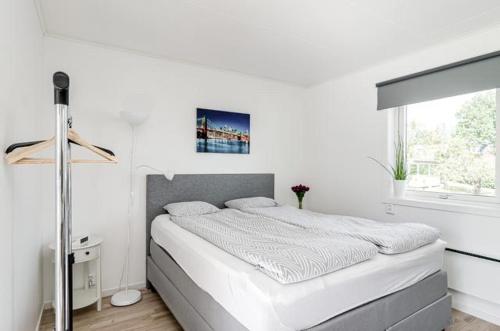 a white bedroom with a bed and a window at Great Stay Guest House Sandviken in Sandviken