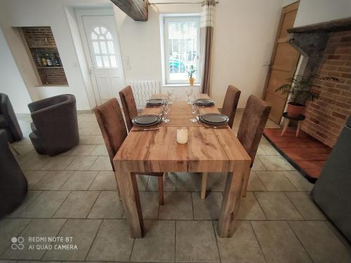 Cette chambre dispose d'une table en bois avec des chaises et d'une cheminée. dans l'établissement Domaine les Béseaudières, à Le Haut des Bordes