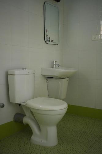 uma casa de banho com um WC branco e um lavatório. em Jungleview Home Stay em Idukki