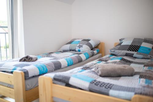 2 camas individuales sentadas una al lado de la otra en una habitación en Apartamenty Pasternik 7, en Suchedniów