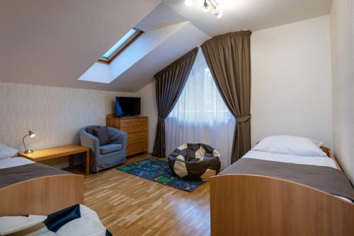 um quarto de hotel com duas camas e uma janela em Penzión SNOW em Tatranska Strba