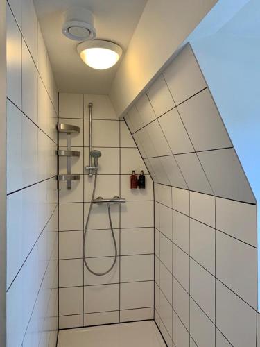 a bathroom with a shower with a shower head at Klooster Nieuwkerk Goirle in Goirle
