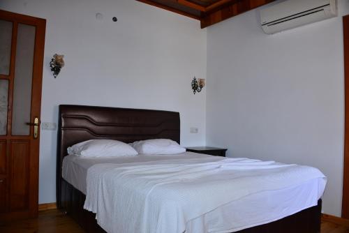 a bed with white sheets and a brown headboard in a bedroom at Aquarius Hotel in Side