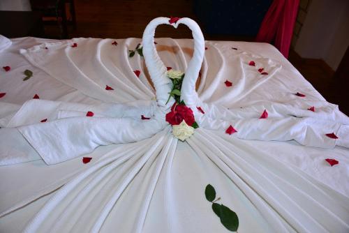 a white wedding dress with roses on a bed at Aquarius Hotel in Side