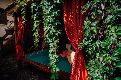 a room with a bed with plants and red curtains at Hotel Barcadam in Banská Štiavnica
