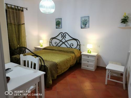 een slaapkamer met een bed en 2 tafels en een stoel bij Sole e Luna Capo Vaticano in Ricadi
