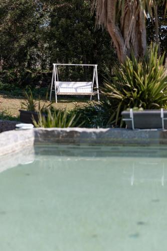 a white bench sitting next to a swimming pool at O Sequeiro in Vila Nova de Famalicão