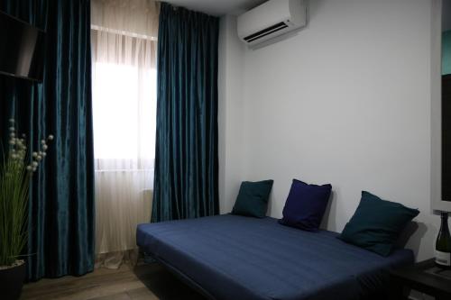 a bedroom with a bed with blue sheets and a window at Bienestar House in Blanes