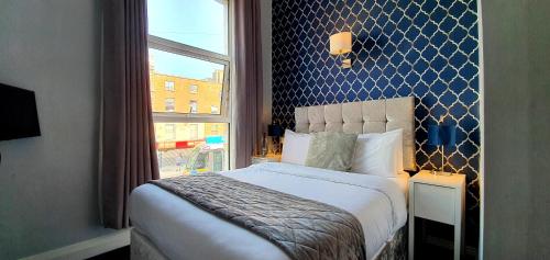 Un dormitorio con una cama grande y una ventana en The Gate Hotel, en Dublín