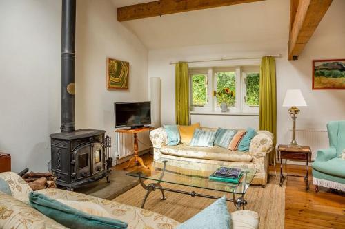 a living room with a couch and a wood stove at Tyas Cottage in Slaithwaite