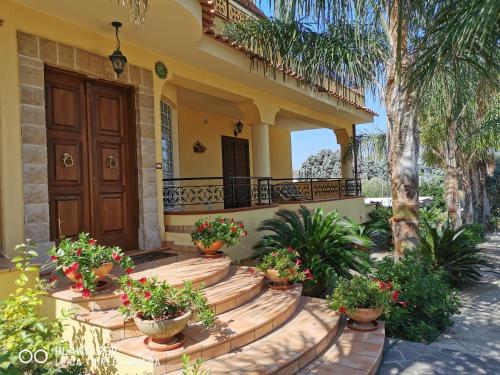 a house with potted plants on the front porch at Sole e Luna Capo Vaticano in Ricadi