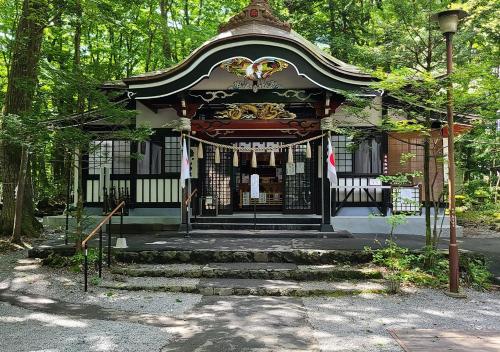 a building with a gate in a park at Bluebird Hotel in Fujikawaguchiko