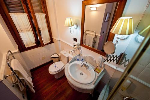 ein Badezimmer mit einem Waschbecken, einem WC und einem Spiegel in der Unterkunft Hotel Rural Hacienda del Buen Suceso in Arucas