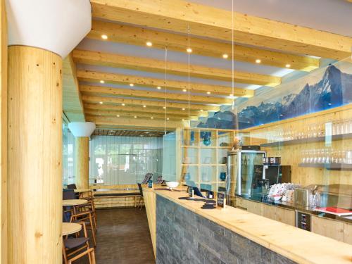 a restaurant with wooden ceilings and a bar with stools at Parkhotel Bad Griesbach in Bad Griesbach