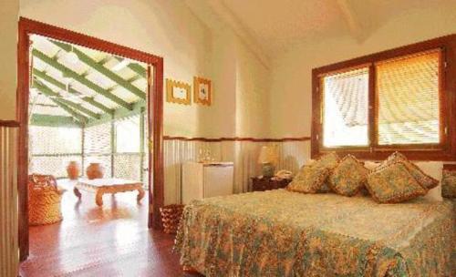 a bedroom with a bed and a large window at Pinctada McAlpine House in Broome