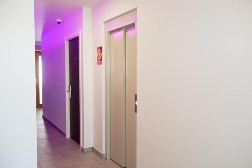 a row of elevators with purple and white walls at Pension San Anton in Melide