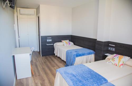 a room with two beds with blue and white at Pension San Anton in Melide